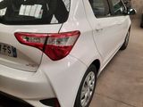 the rear end of a white toyota yaris parked in a garage