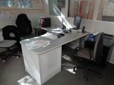 a desk with a computer and a chair in a room