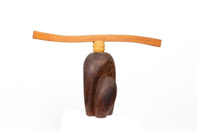 wooden sculpture of a cat with a long neck on a white surface
