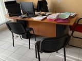 a desk with two computers and two chairs in the room