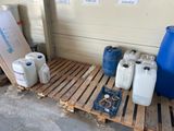 plusieurs récipients remplis d'eau posés sur une palette à côté d'un fût bleu
