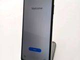 a close up of a cell phone on a stand with a welcome screen