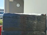 a large black box sitting on top of a pallet next to a building