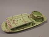 une assiette verte sur laquelle sont posées une tasse et une soucoupe