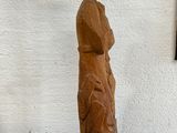 statue of a woman holding a bird on a pedestal in front of a white wall
