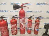 several fire extinguisors are lined up in front of a wall