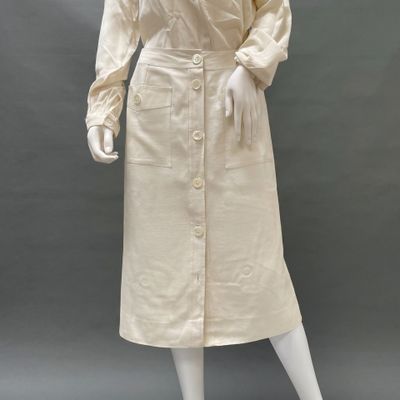 an image of a mannequin wearing a white dress and hat
