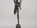 a bronze statue of a man holding a cross on a pedestal