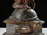 a statue of a woman holding a cat on top of a table