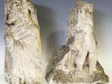 une paire de statues en pierre représentant une femme et un homme, posées sur un rocher