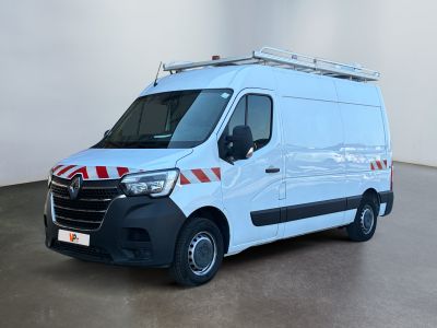 La camionnette blanche est garée dans une grande pièce ; elle porte une bande rouge et blanche sur le côté.