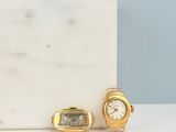 two watches and a watch sitting on a table