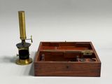 a small wooden box with a microscope on top of it
