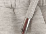 a small metal tube sticking out of the pocket of a pair of sweatpants