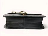 a black purse with a chain hanging from it ' s handle