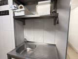 a kitchen with a sink and a trash can in it