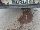a dirty parking lot with a dirty license plate on the back of a truck