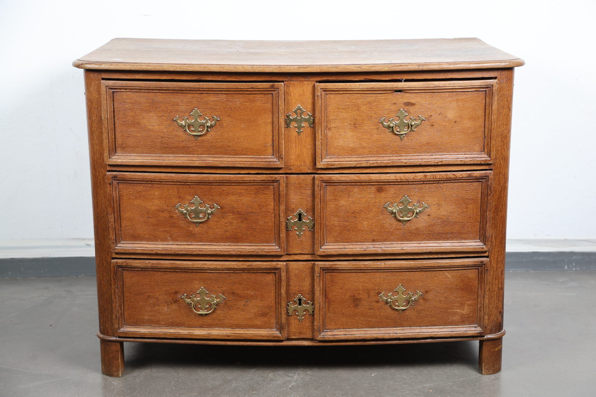 Commode galbée en chene, ouvrant à quatre tirois en facade.