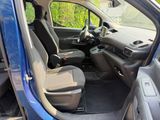 the interior of a small blue car with two seats and a steering wheel