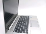 a silver laptop with a black keyboard on a white surface