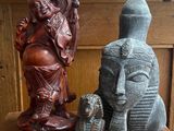 a statue of a man holding a staff next to a statue of a woman