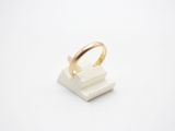 a white marble ring with a gold band sitting on top of a white marble block