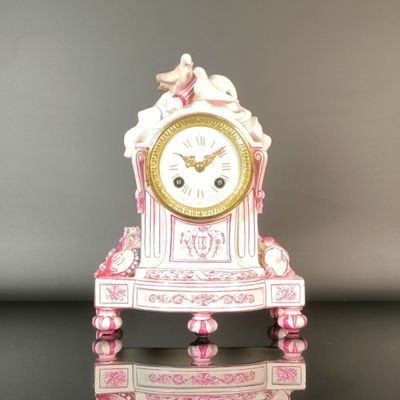 a pink and white clock sitting on top of a table