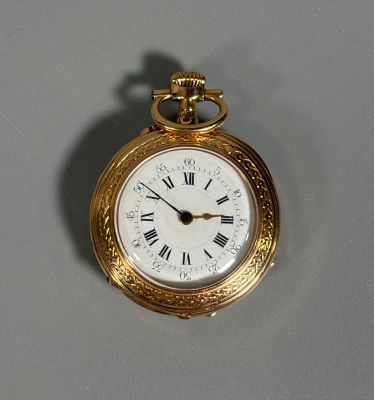 a gold pocket watch with roman numerals on the face