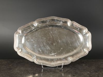 une image représentant un plateau en argent posé sur une table, sur fond noir