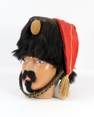 un chapeau noir et rouge orné d'une moustache, posé sur la tête d'un mannequin