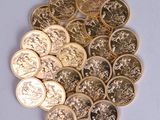 a pile of gold and silver coins on a white surface