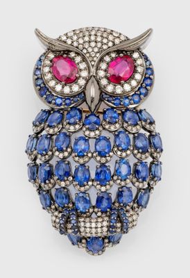 an image of a blue and white owl broochle with red eyes