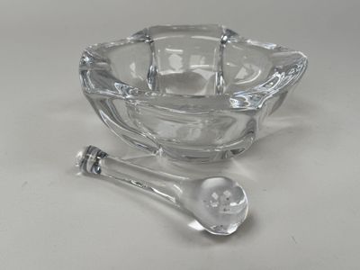 a glass bowl with a spoon and a spoon rest on a table