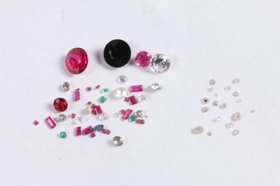 Plusieurs pierres de différentes couleurs sont dispersées sur une surface blanche