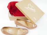 pair of nude colored shoes in a box with a red bag