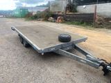 a trailer with a flat bed on the side of the road