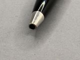 a black pen with a silver tip sitting on a table
