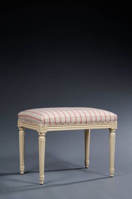 a white bench with a striped upholstered seat and legs