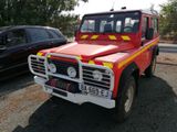 un camion de pompiers rouge et jaune garé à côté d'une voiture noire
