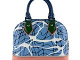 the blue and pink handbag is sitting on a white surface