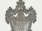 une plaque métallique sur laquelle est représenté un blason