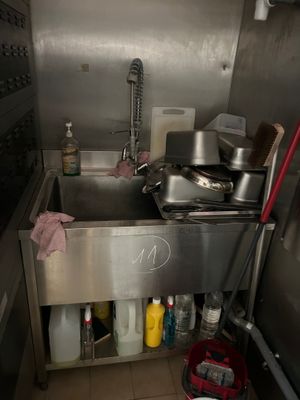 une cuisine équipée d'un évier et de nombreux ustensiles de cuisine