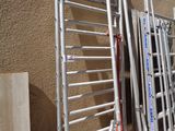 Plusieurs échelles sont alignées contre un mur près des toilettes.