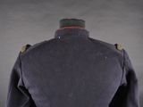 the back of a military jacket with a red stripe on it