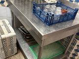 a metal table with a basket on top of it