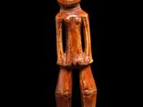 une figurine en bois représentant un homme, les mains dans les poches