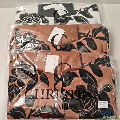 trois chemises dans un sac en plastique orné de fleurs noires et blanches