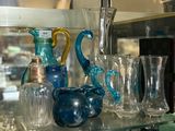 many glass vases on a glass shelf in a store