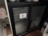 un réfrigérateur avec une porte vitrée dans laquelle se trouvent des assiettes
