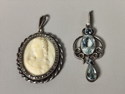 deux pendentifs représentant chacun une femme et une topaze bleue